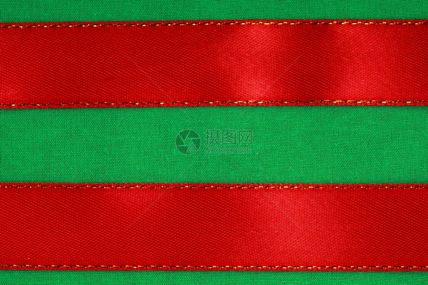 纺织品背景上的空横幅绿色布质条上的红丝带有复制空间图片