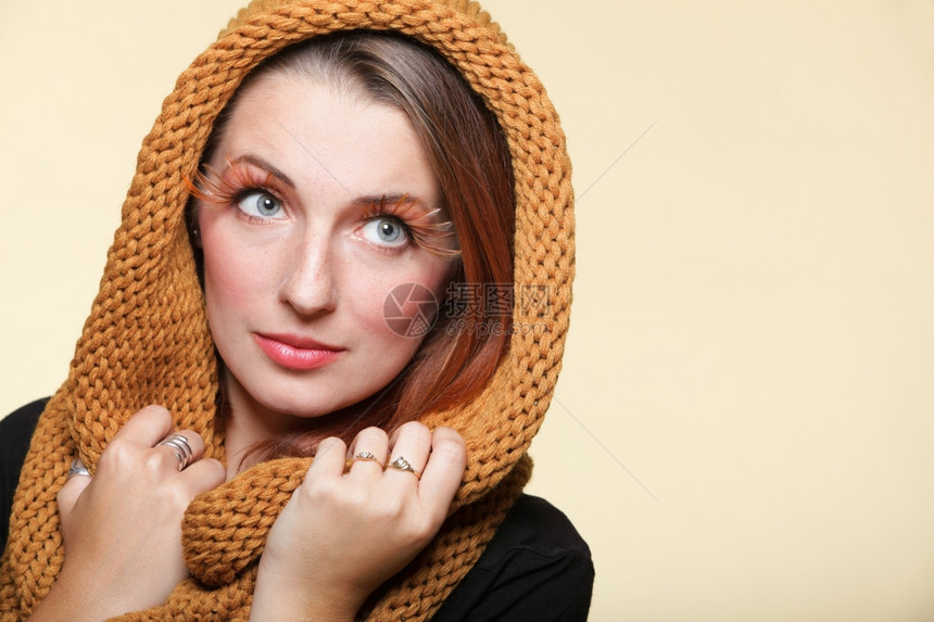 秋天时尚的年轻女青戴着温暖的橙色围巾装有创意化妆品的假眼睫毛图片