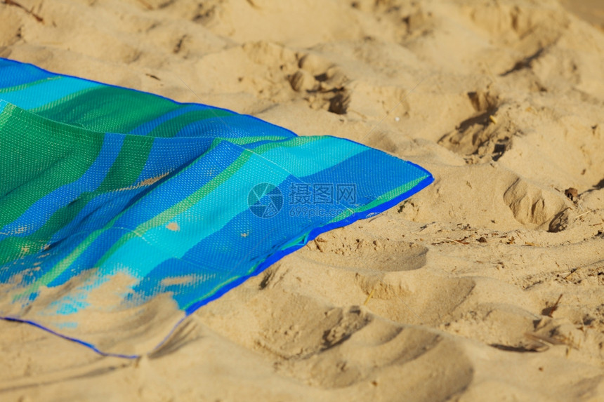 暑假关闭海滩上空的条纹蓝色绿毛毯阳光晒黑在海边放松夏天图片
