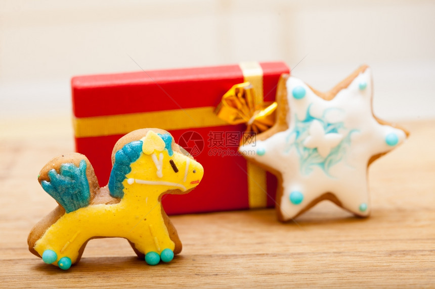 土制姜饼小马和明星有冰淇淋和彩色装饰有金丝带的红礼品盒克里斯马和节日手工制作的概念图片