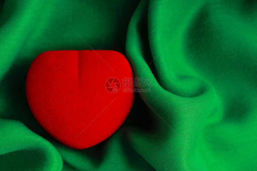 红宝石盒心形礼物赠在绿色织物上抽象布图片