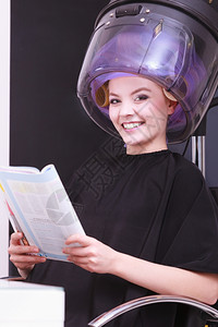 年轻女客户在美发容院阅读杂志背景图片