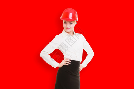 穿着红色安全头盔的女建筑师红色背景空白的复制间大楼图片