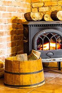 火桶在家冬天用橙色火焰和木柴关闭壁炉在桶内加热背景