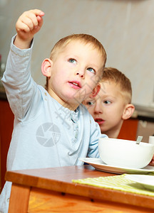 两位金发兄弟男孩在桌边吃玉米片早餐图片