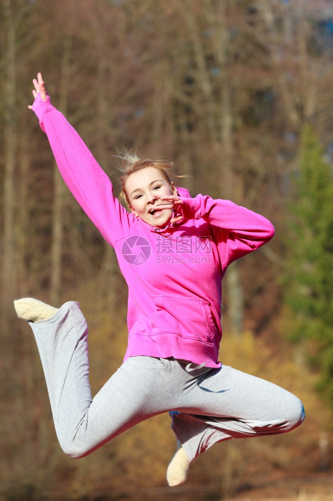 穿着粉红色运动服的年轻女孩在户外跳高健康活跃的生方式图片