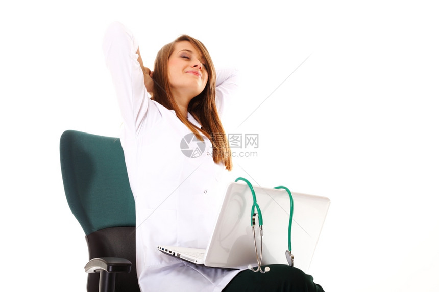 从事笔记本电脑工作的女医生在白种背景的情况下在工作场所伸展图片