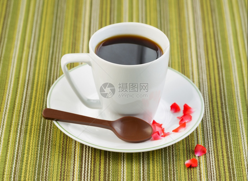 黑咖啡的近照片在小杯子里用巧克力勺子红玫瑰花瓣在碟子上图片