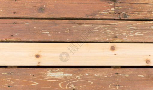 在户外甲板上滑落的木柴旁边单一新雪松木板的横向照片图片