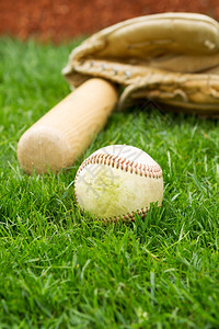 旧棒球蝙蝠和手套的垂直照片底草和红色基线图片