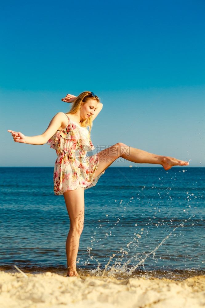 暑假穿期服的姑娘在海岸上泼水年轻女人在海上放松愉快夏天图片