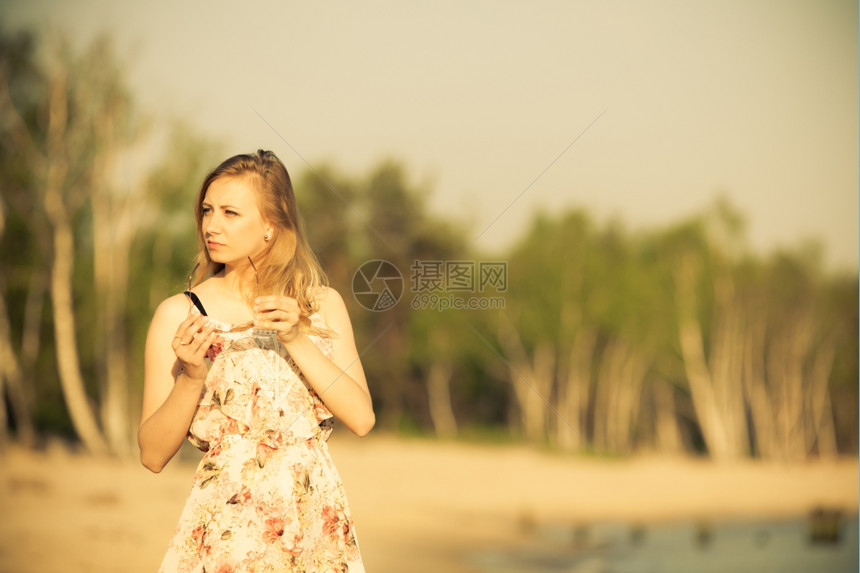 暑假穿期服装的女孩独自在空旷的海滩上行走年轻女人在海上放松夏天图片