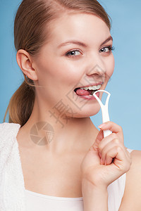 年轻女孩微笑用蓝色的清扫舌头每日牙科护理和口腔卫生工作室拍摄图片