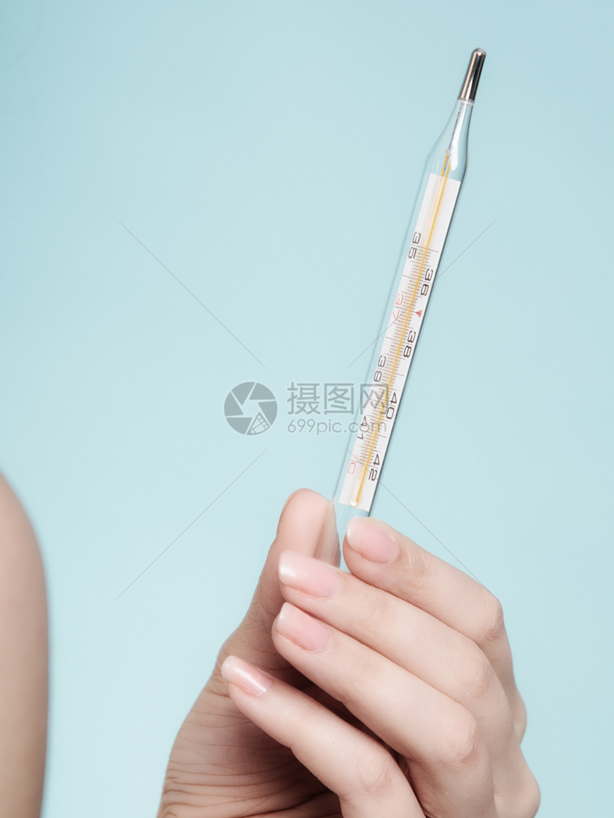 阴女用蓝色手医疗汞温度计关闭图片