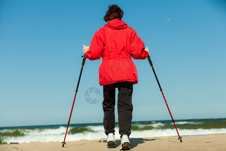 北欧人散步女在海滩上徒步旅行积极健康的生活方式图片