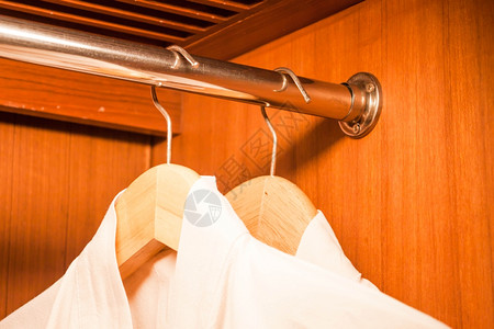 白浴袍挂在衣柜的木架上图片