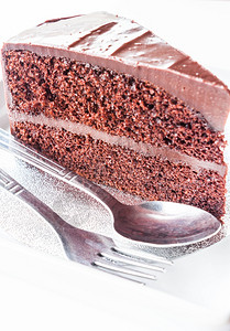 一块巧克力蛋糕配勺子和叉图片