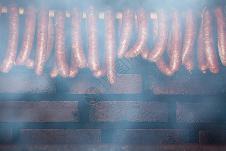 吸烟室传统食物家用烟熏香肠肉挂在家用烟屋里背景