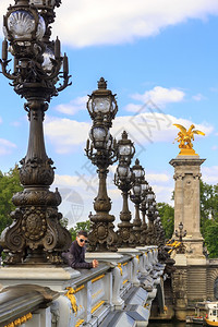 在巴黎的一位年轻人在亚历山大三世桥上在法国巴黎图片