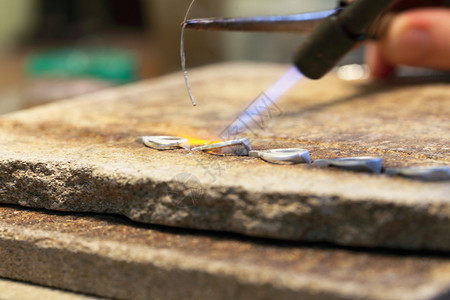 珠宝商在工作时的手银焊黄金匠在打工和焊接背景图片