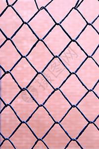 粉红背景的蓝色铁丝网围栏图片