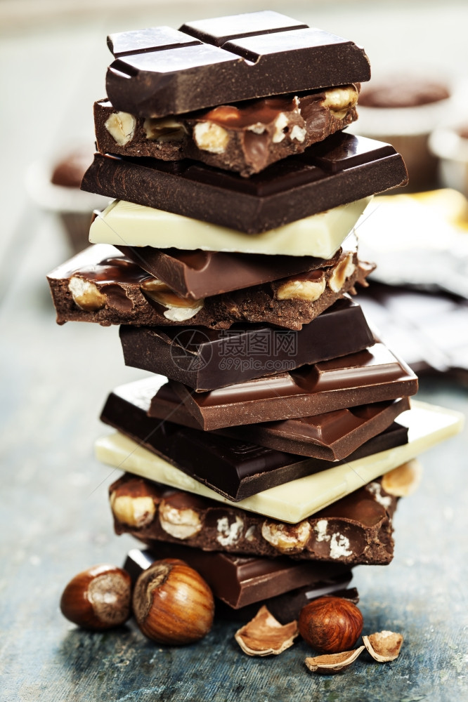各种白色黑和牛奶巧克力配有坚果在木板上图片