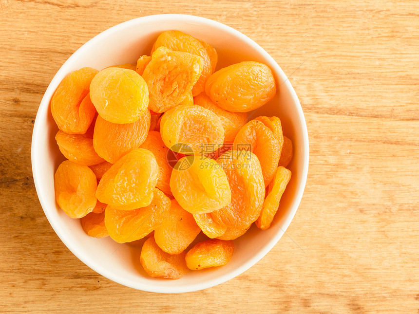 健康的营养饮食一碗木桌底的干杏子图片