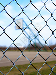 模糊篮球场背景的金属网状铁丝栅栏图片