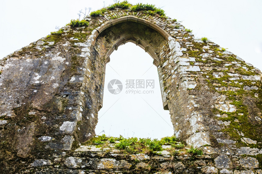旧石头堡垒或教堂修道院和天空的拱门窗口建筑细节图片