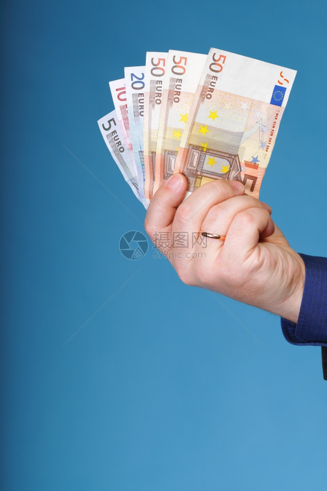 蓝背景男手持欧元钞票图片