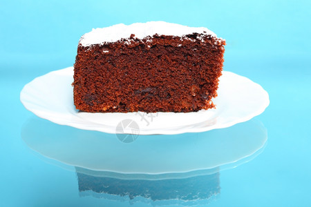 白盘上含冰糖的巧克力蛋糕蓝色背景图片