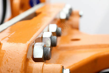 工业机械橙色件细节上的螺丝和栓图片