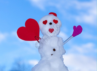 穿着红围巾的情人节小雪外出有心纸短信冬季节情人39日蓝天背景图片