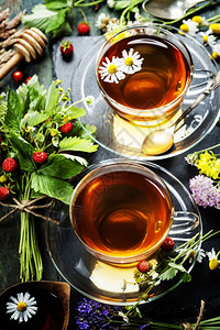 含蜂蜜的草药茶野生果子和木本的鲜花图片