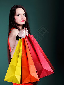 绿色背景的纸质多购物袋销售和折扣概念图片