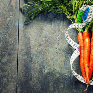 新鲜胡萝卜和计量带饮食和健康概念图片