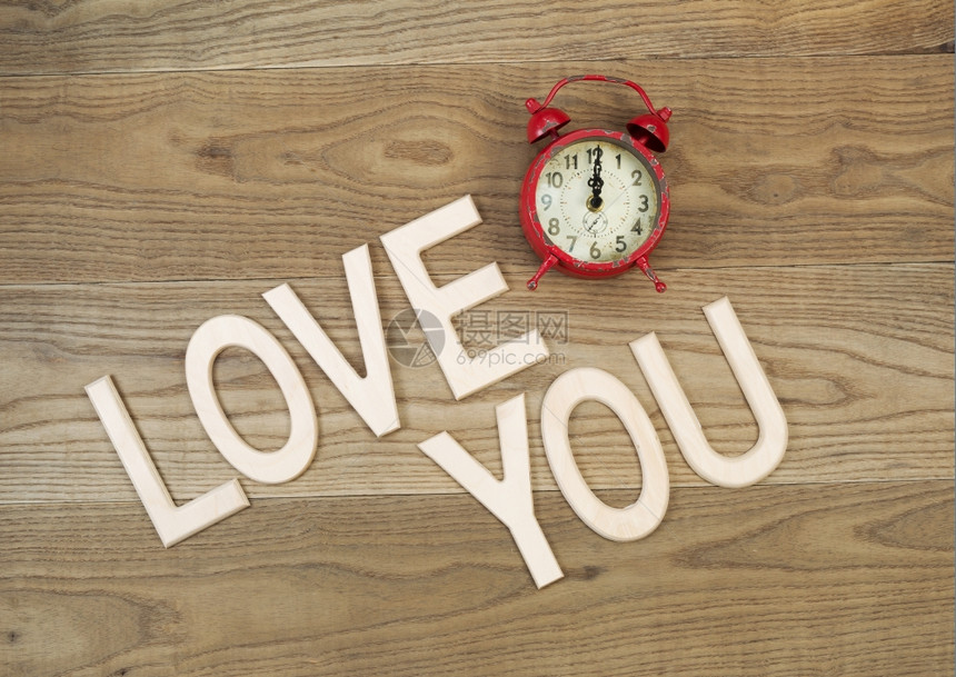 一张旧桌顶闹钟和大木字母上面的图景写着在生木爱你图片
