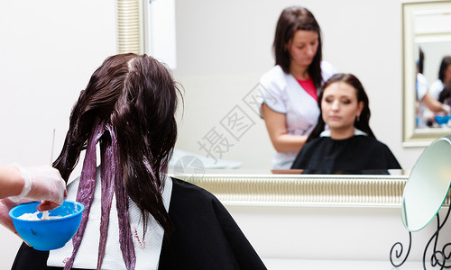 专业女理发师在设计廊对女客户适用彩色妇女染发头色过程背景