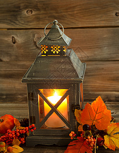 亚洲旧设计灯笼和白蜡烛的垂直前方视图里面闪亮光在生锈木上装饰秋图片