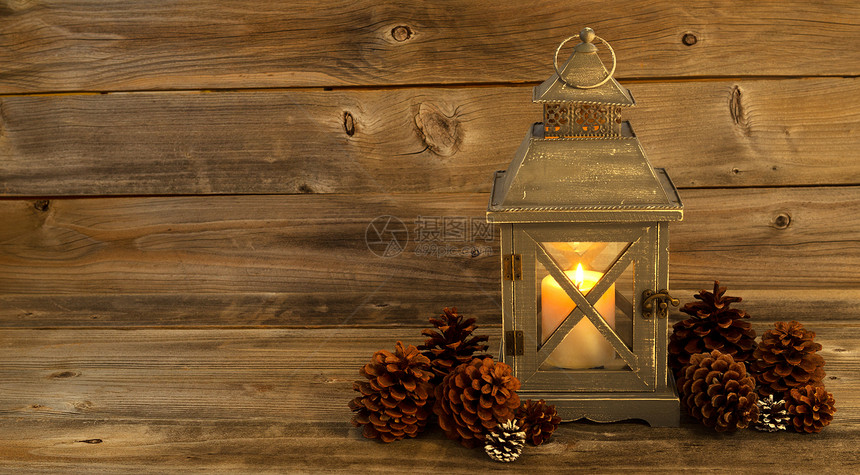 亚洲古旧设计灯笼和白蜡烛的横向前方视图里面闪亮光生木上自然的松锥形装饰图片