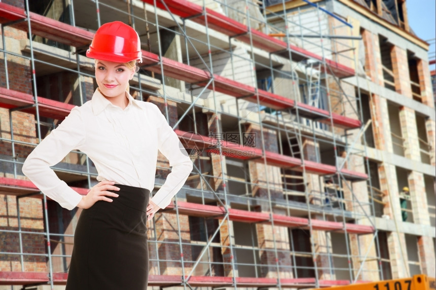 建筑工地的红色安全头盔女建筑师大楼图片