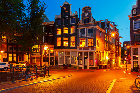 荷兰阿姆斯特丹桥和典型荷兰德州人住宅的夜间城市景象图片