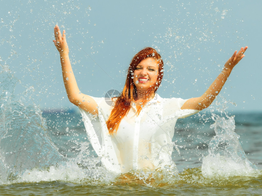 度假女孩在海岸上泼水年轻女人在海上放松愉快暑假图片