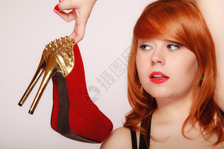 穿着红色高跟鞋的时装女郎穿着红色高跟鞋穿着金制鞋妇女喜欢子概念图片