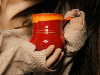热饮喝杯红茶或咖啡的杯子由女亲手关闭穿着暖和毛衣的女人自己暖和图片