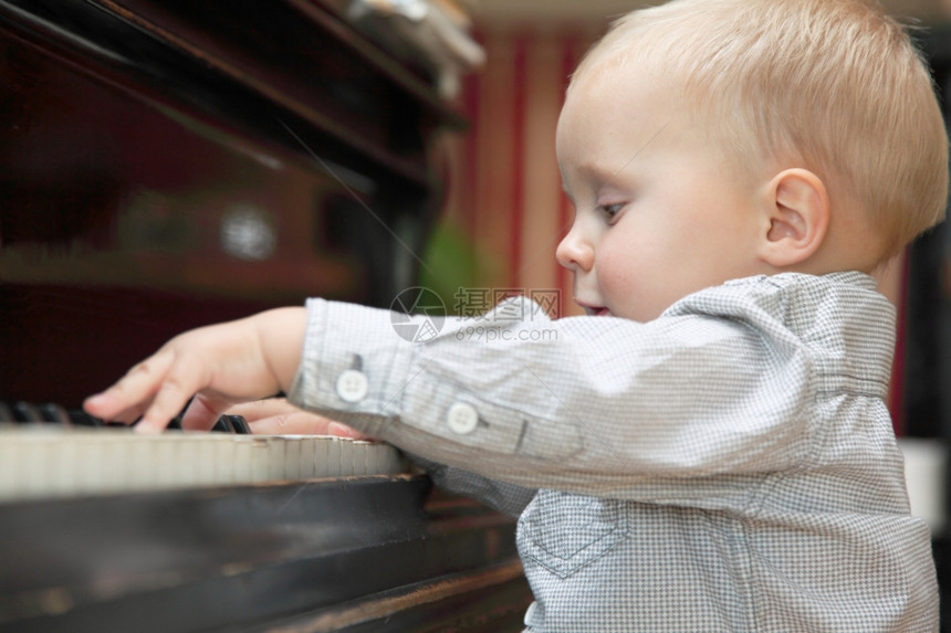 两岁小男孩在室内弹钢琴图片
