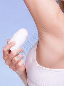 逆止器女身体的一部分女孩在臂窝中施用棒除臭剂年轻女将抗吸入剂放在下日常皮肤护理和卫生工作室中弹背景
