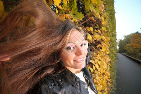 年轻女子秋天的叶黄色绿女孩花园背景长头发图片