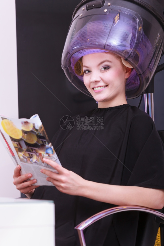 年轻女客户在美发容院阅读杂志图片