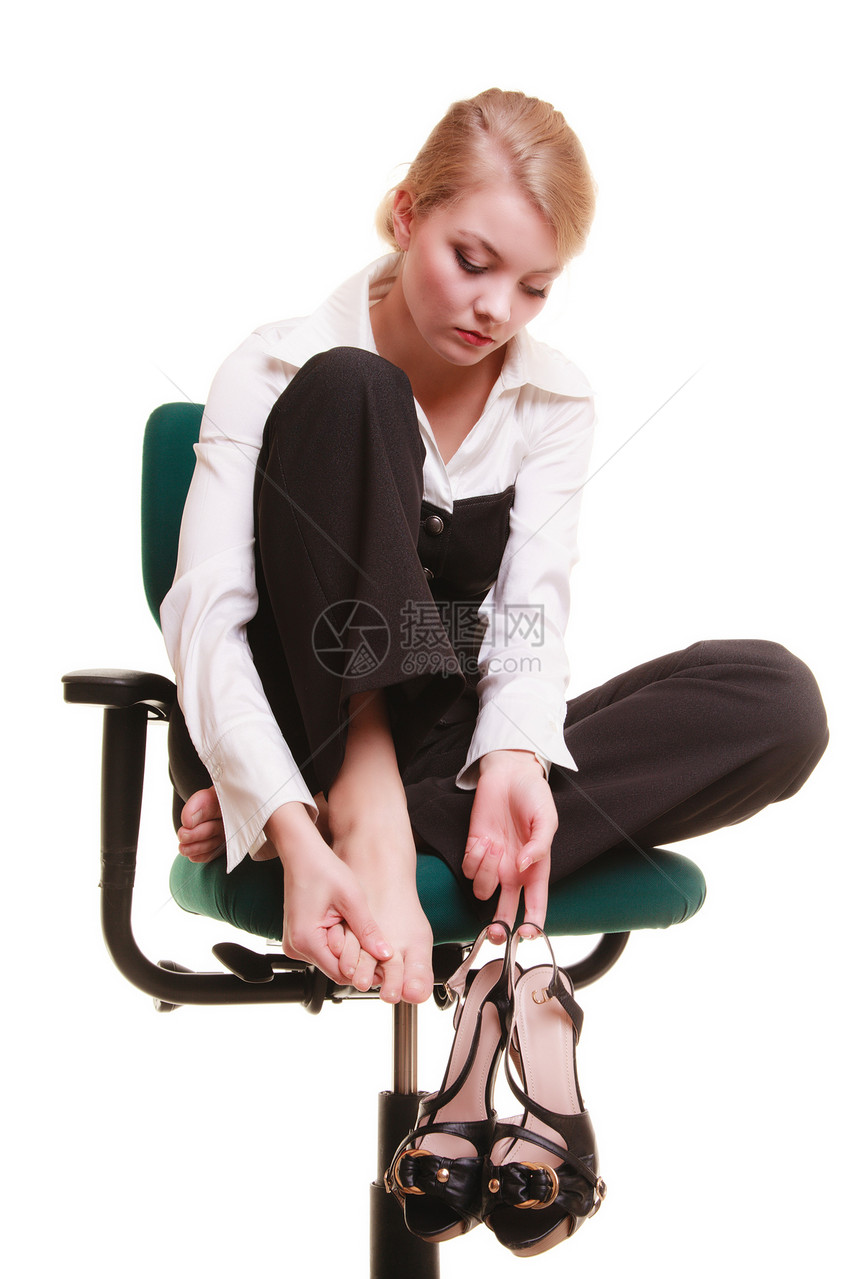 女商人脚痛累年轻女用白椅子按摩她的脚图片